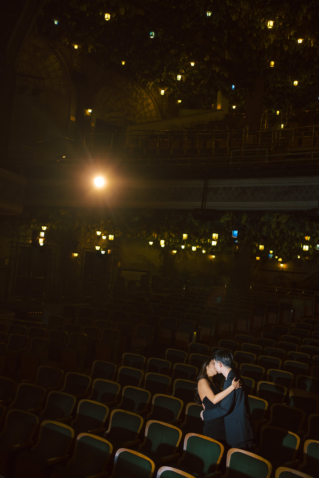 Bryan and Sheryl embracing beneath the theatre lights